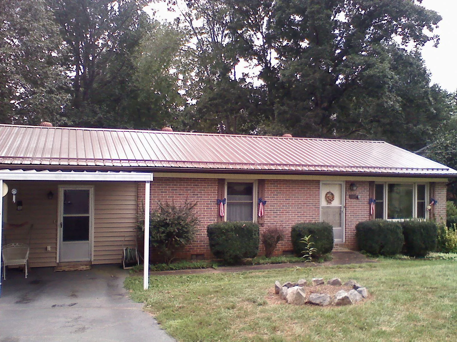 Bronze metal roof and carport on a brick ranch home — Roof Repair work by our crew in Machipongo